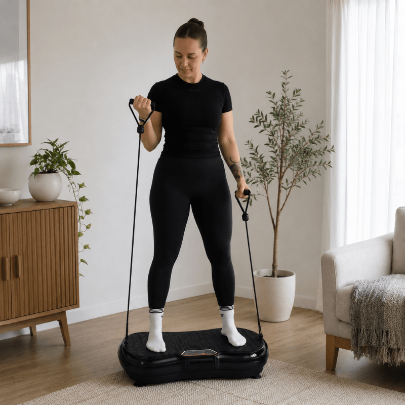 Woman using the StepTone Vibration Plate in Black with resistance ropes