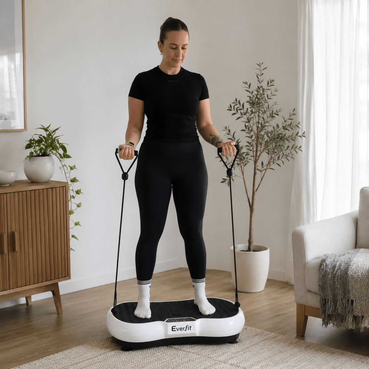 Woman using the StepTone Vibration Plate in White with resistance ropes